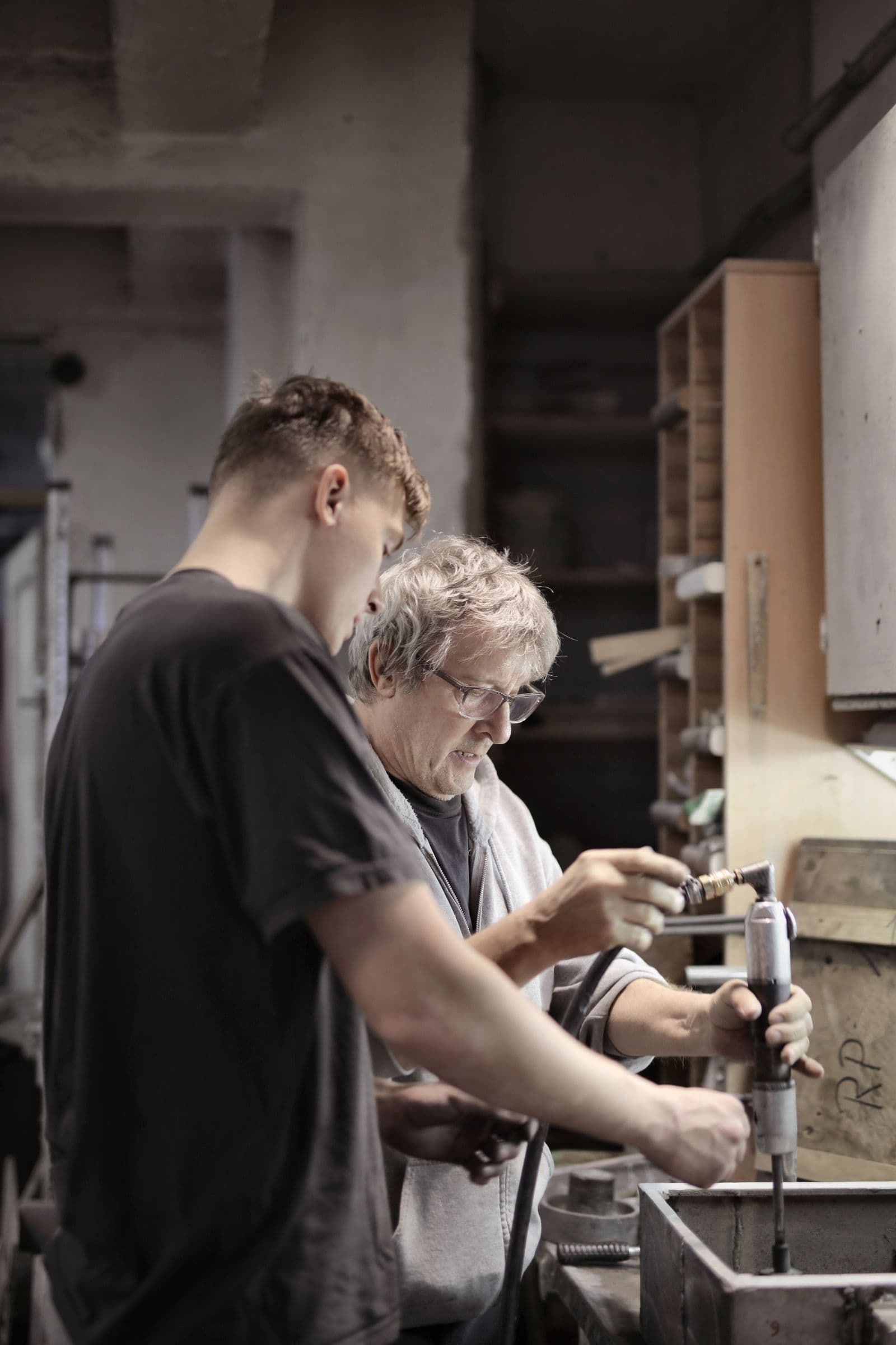 An experienced owner demonstrating a workshop process to a younger steward.
